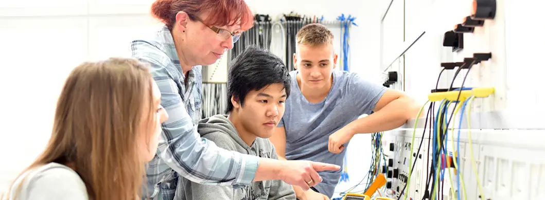 Quatre personnes travaillent ensemble dans un laboratoire lumineux en utilisant des appareils de mesure électroniques avec des câbles connectés sur une table.

Description générée par IA