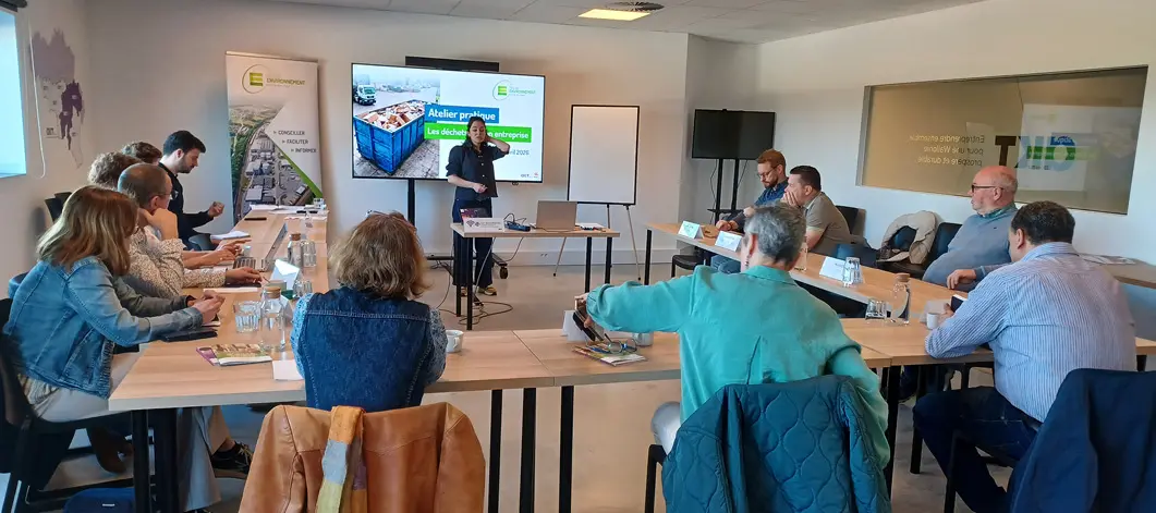 Des personnes assises autour de tables en U assistent à une présentation dans une salle de réunion moderne avec un écran affichant des informations.

Description générée par IA