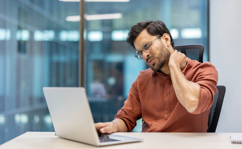 Une personne portant une chemise orange est assise à un bureau avec un ordinateur portable devant elle et se masse le cou dans un environnement de bureau moderne.

Description générée par IA