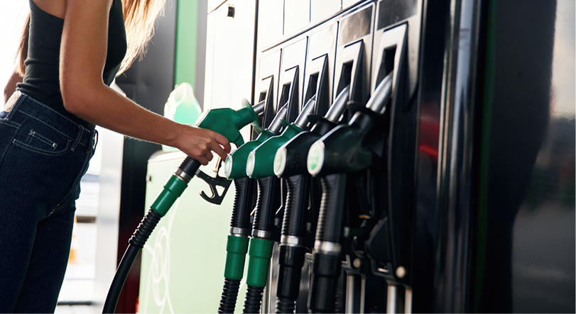 Une personne tient une pompe à essence verte pour faire le plein à une station-service.

Description générée par IA
