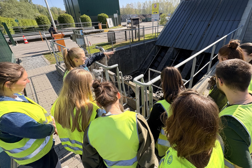 Un groupe de personnes portant des gilets de sécurité jaunes observe attentivement une installation industrielle extérieure sous un ciel ensoleillé.

Description générée par IA